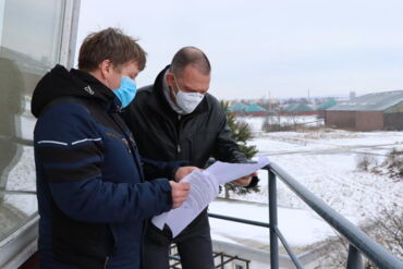 Auf dem Foto sieht man Oberbürgermeister Sven Mißbach und Landrat Ralf Hänsel im Gespräch. Im Hintegrund ist der Flugplatz Großenhain zu erkennen.