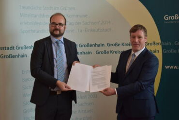 Das Foto zeigt den Sächsischen Kultusminister, Christian Piwarz, wie er OB Dr. Mißbach den Fördermittelbescheid überreicht.