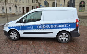 Das Foto zeigt das blau-weiße Dienstfahrzeug des Ordnungsamtes Großenhain. Dies ist als Schriftzug auf dem Fahrzeug erkennbar.