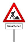 Das Foto zeigt das Verkehrsschild "Baustelle". Darunter steht auf einem weißen Schild das Wort "Bauarbeiten".