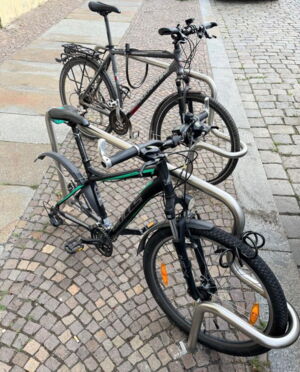 Das Foto zeigt einen Fahrradständer mit zwei Fahrrädern. Bei einem Fahrrad fehlt das Hinterrad.