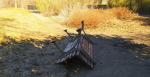 Das Foto zeigt eine umgeworfene Sitzbank. Im Hintergrund sieht man die Faunhöhe in Großenhain.
